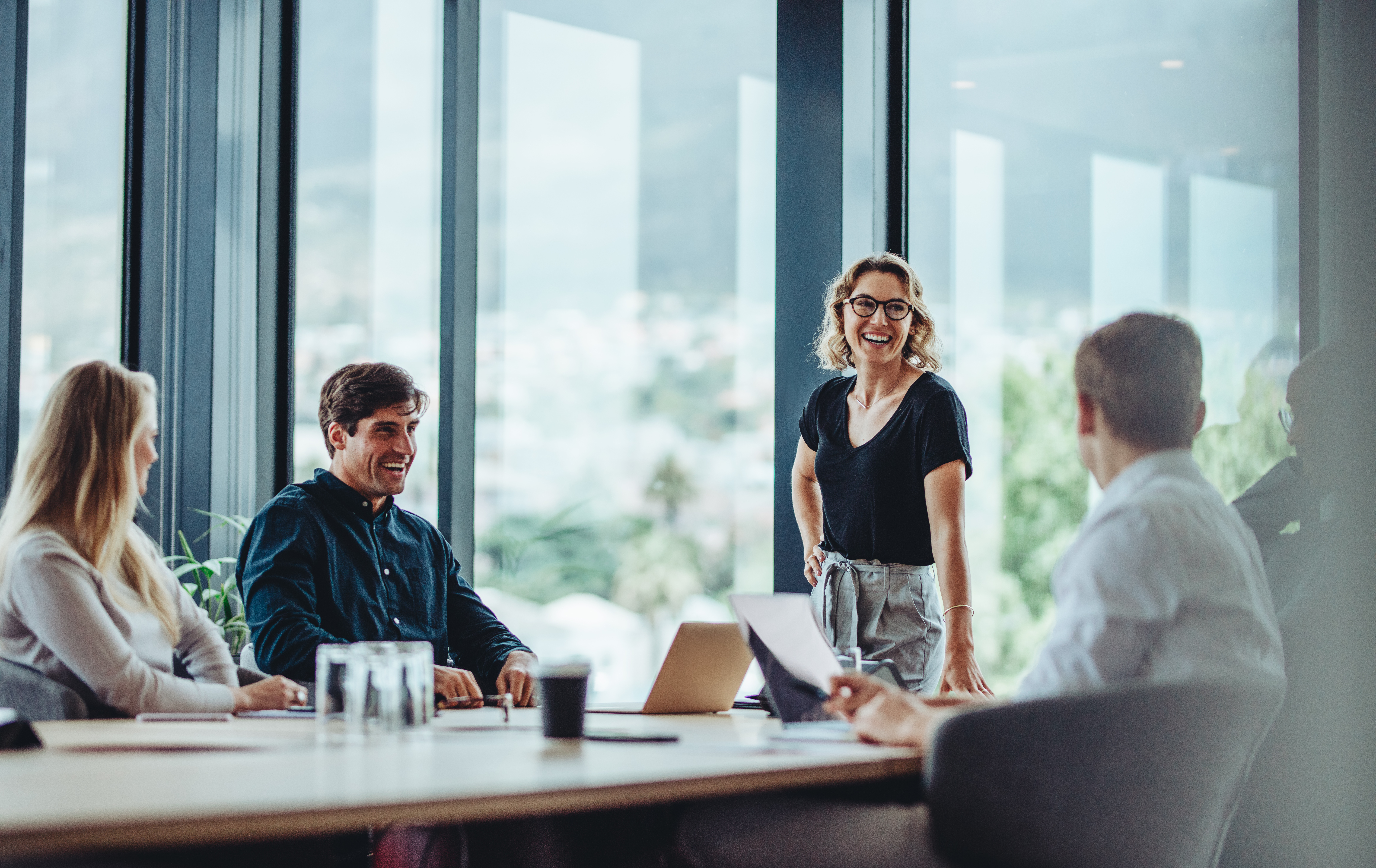 Four people sat around a board room table having a meeting