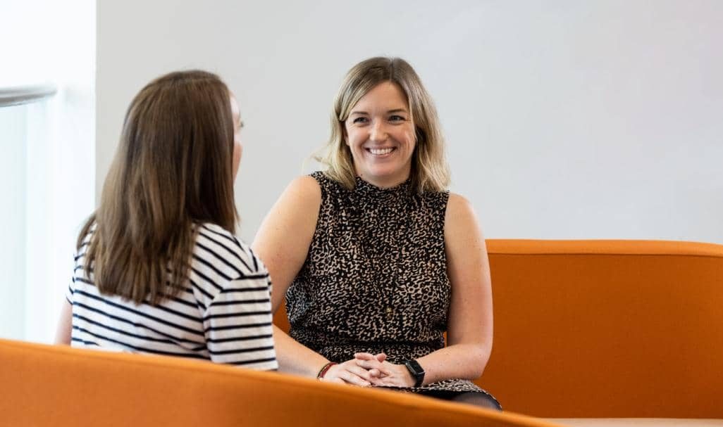 Two AAB employees talking and smiling.