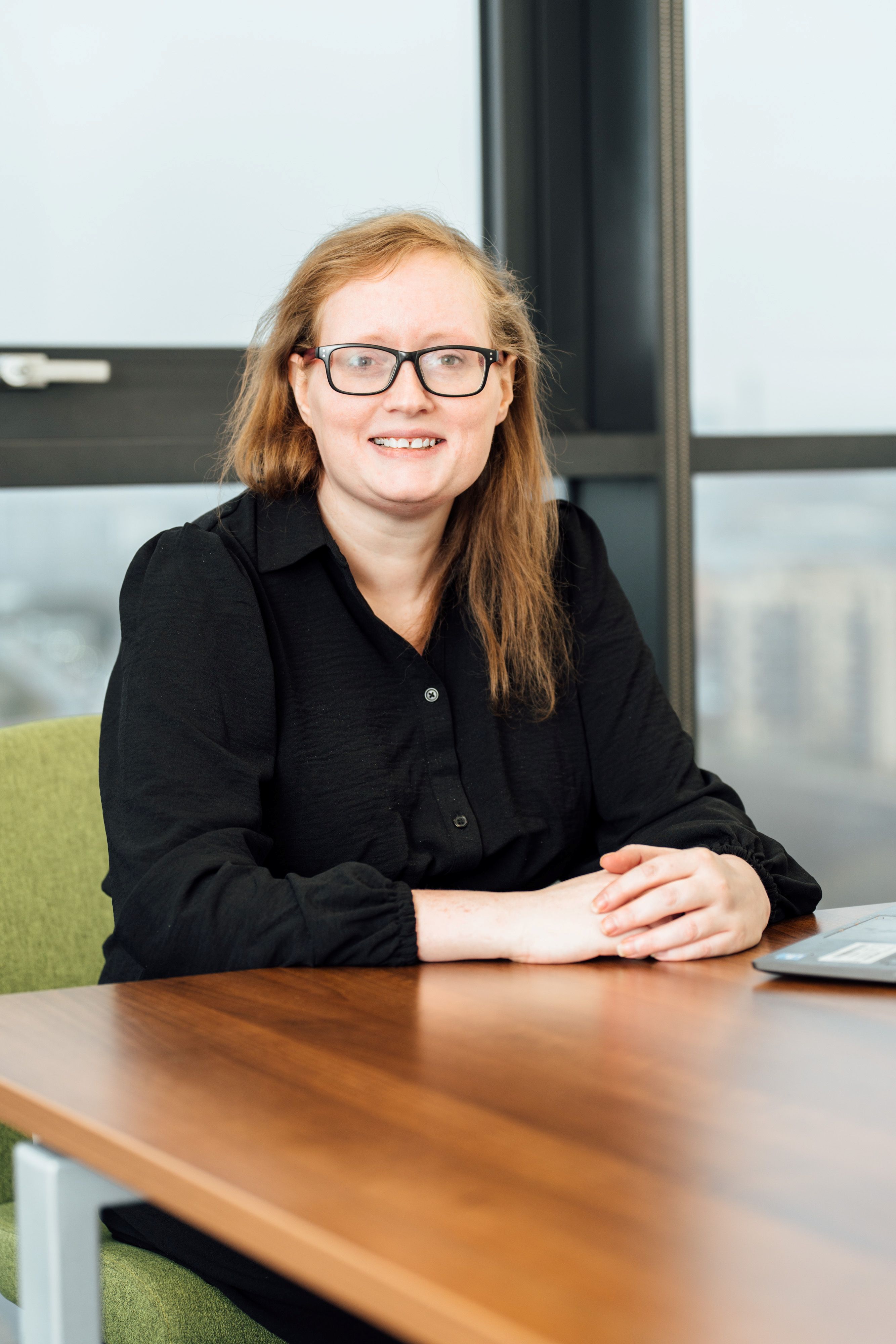 Clare Walker sitting at desk smiling at camera