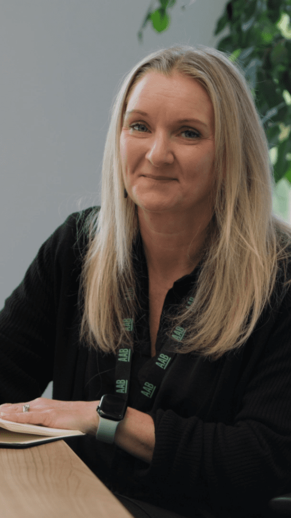 An image of Vicky Madigan wearing a black top and writing in her book.