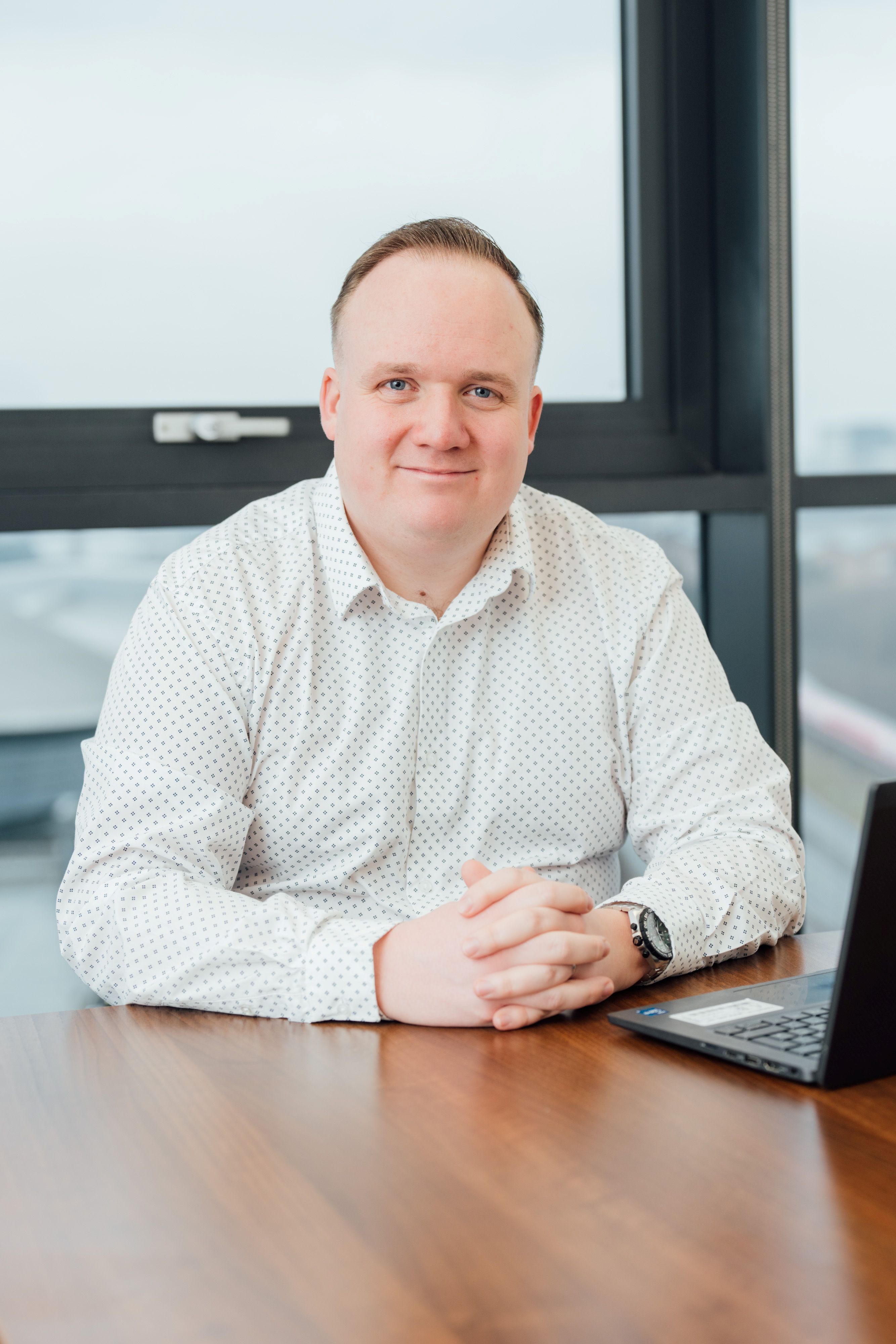 Josh McCranor sitting at desk smiling at camera