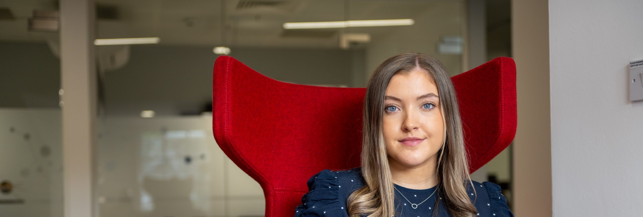 Woman seated in a red chair, employee of AAB business tax services