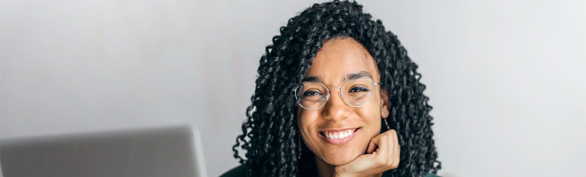An image of a women with curly black hair smiling at the camera.