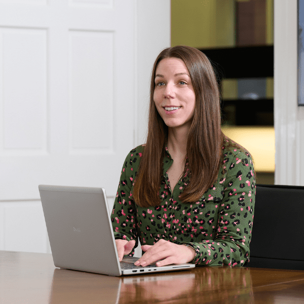 An image of Laura Cowling sitting a desk with a laptop.