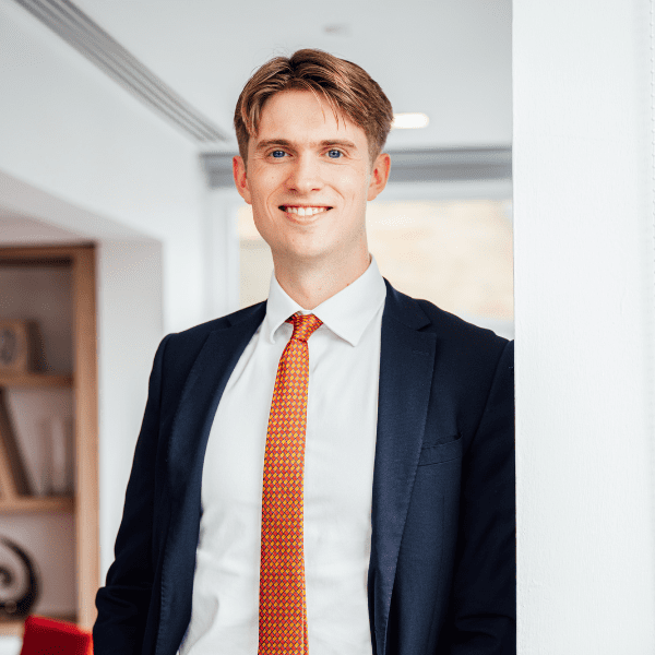 An image of Thomas Hill standing in the office and smiling at the camera.