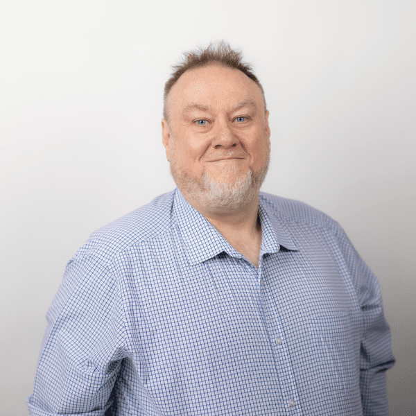 An image of Richard Maloney wearing a blue shirt and smiling at the camera.