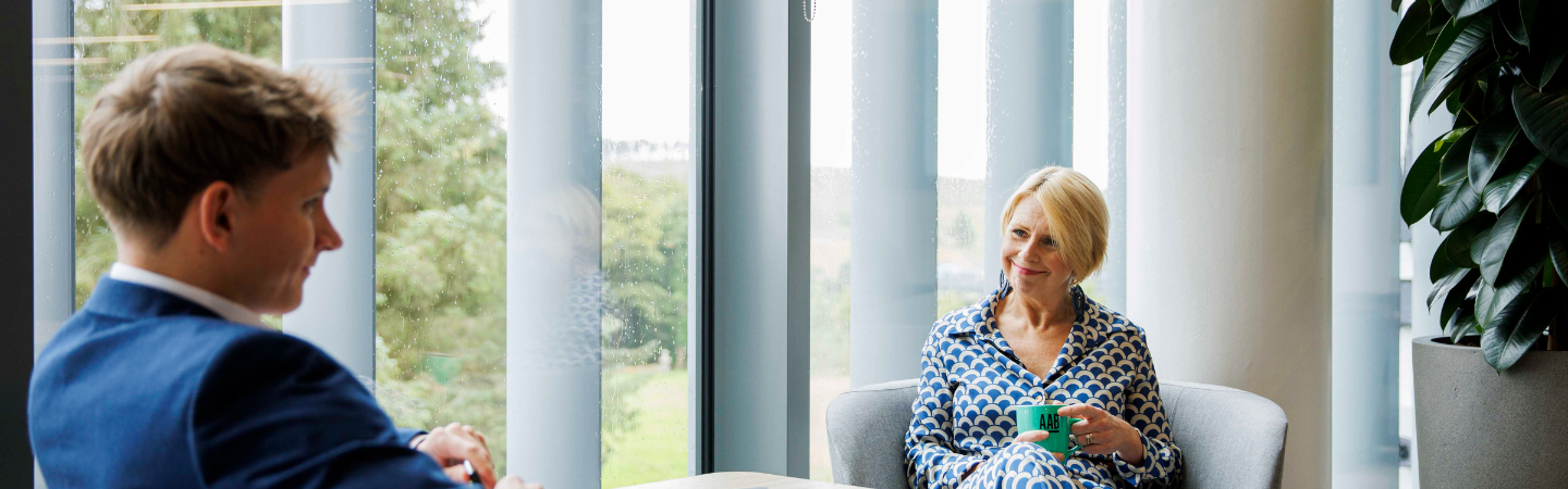 An image of Julie Arbuthnott sitting in an office and smiling at the camera.